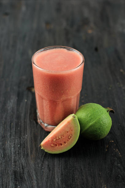 Red Guava Juice Served on a Glass, Above Black Wooden Table. Copy Space for Text or Advertisement stock photo