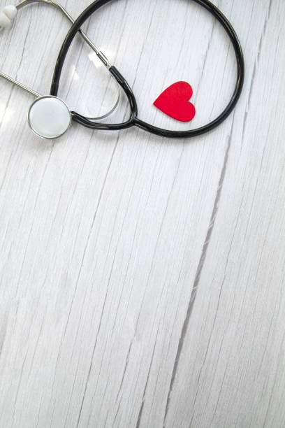 red heart and a medical stethoscope, insurance,hospital,world health day concept top view on white wooden background copy space - coronatest netherlands stockfoto's en -beelden