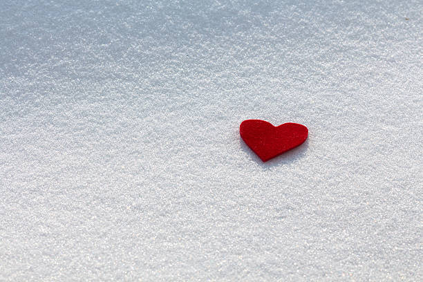 Red heart in the snow stock photo