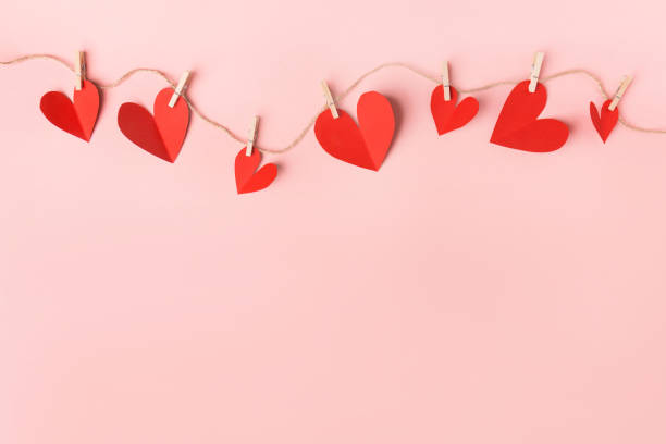 Red hearts on pink background Beautiful valentines day paper hearts hanging on rope on pink background. View from above. Valentines Day Concept. valentines stock pictures, royalty-free photos & images