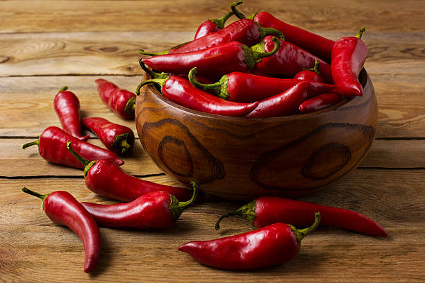 Red hot chilli pepper in wooden bowl Red hot chilli pepper in wooden bowl. Spicy food concept. cayenne pepper stock pictures, royalty-free photos & images
