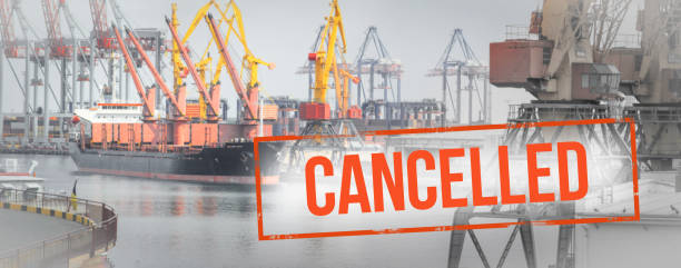 Red inscription cancelled on a blurred background  ship and  cranes in sea port. stock photo