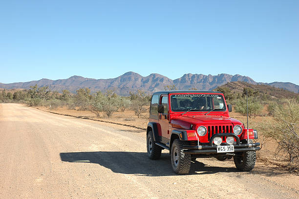 Red Jeep Wrangler driving offroad rocky track in Flinders Ranges stock photo