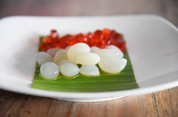 Red jelly and white palm fruit names "KOLANG KALING", placed on white plate on brown wooden table Red jelly and white palm fruit names "KOLANG KALING", placed on white plate on brown wooden table kolang kaling stock pictures, royalty-free photos & images