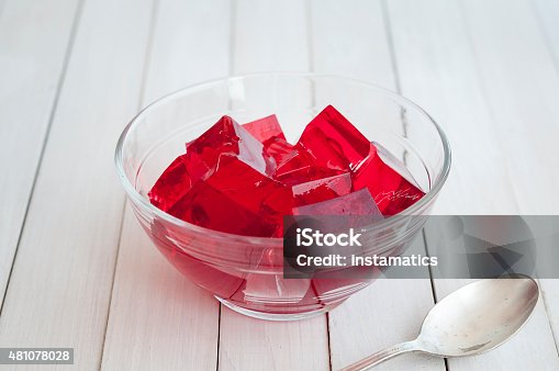 istock Red jelly cubes in glass bowl with silver spoon 481078028