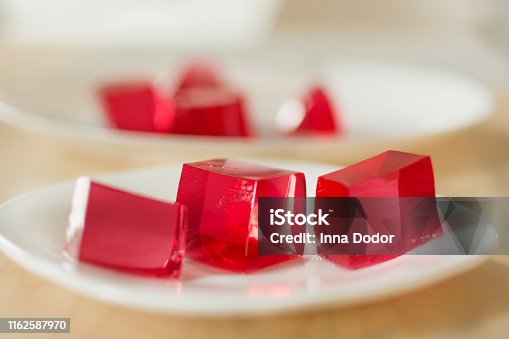 istock Red jelly cubes on white plate background. 1162587970