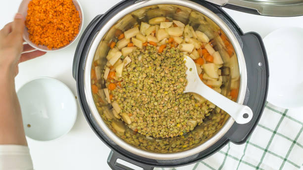 Red lentils, green lentils, and some ingredients close up in a pot. Multi cooker lentil soup recipe stock photo