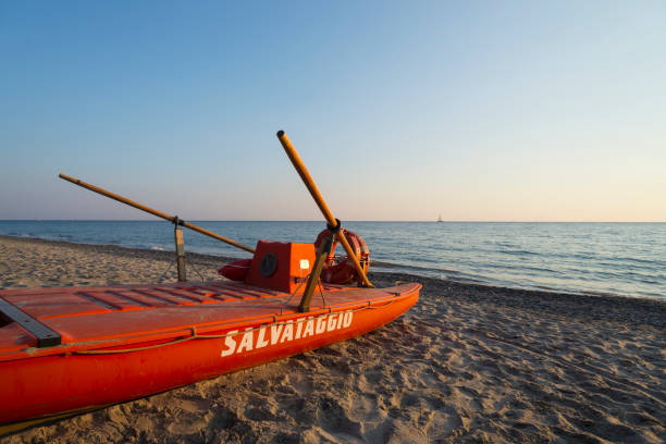 Red lifeboat  at sunset on the Mingardo beach at the Mediterranean Sea near Palinuro in the Cilento region in southern Italy stock photo