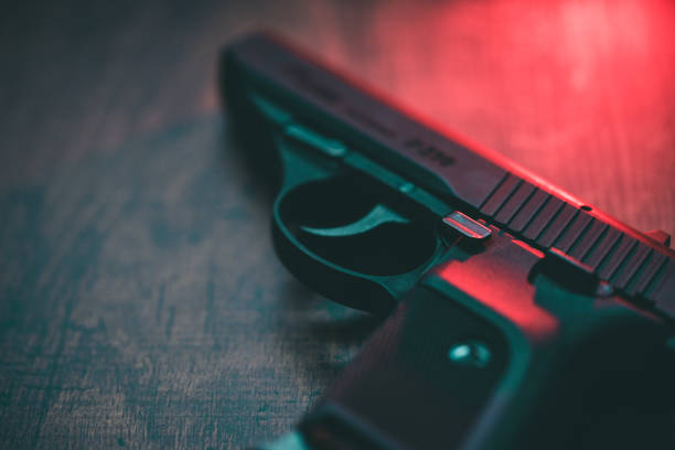 pistolet ręczny z czerwonym oświetleniem - gun violence zdjęcia i obrazy z banku zdjęć