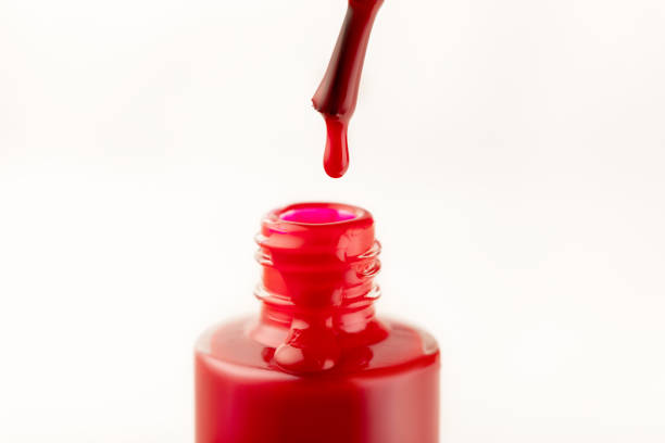 red nail polish with a drop on a brush close-up isolate on a white background, beauty concept - nail polish bottle close up stockfoto's en -beelden