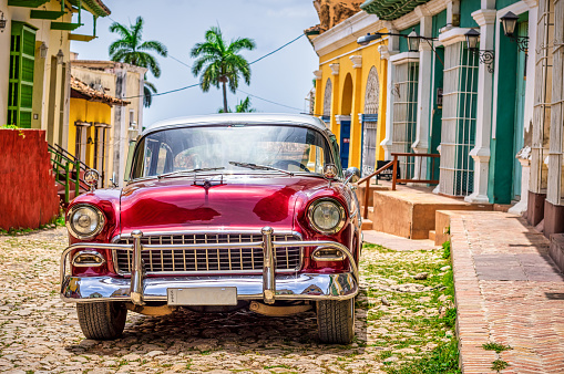 red Vintage car near colonial houses in the old town of Trinidad, Cuba