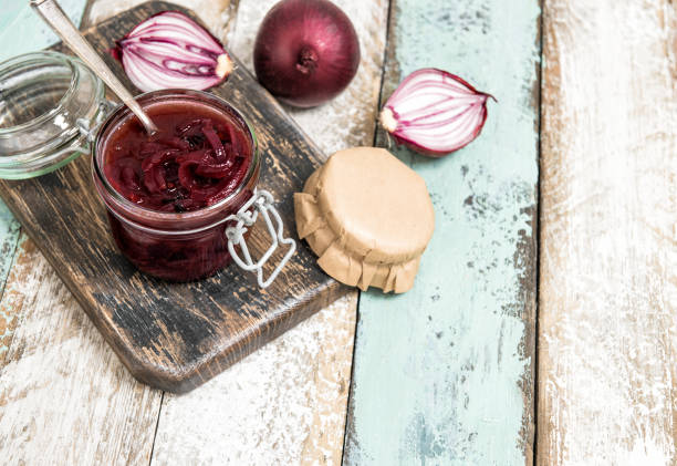 Red onion marmalade in jar Vegetable jam Red onion marmalade in jar. Vegetable jam on rustic wooden background. Preserving ingredients chutney stock pictures, royalty-free photos & images