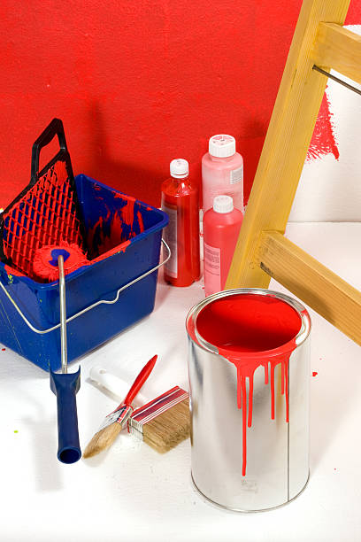 Red painting with ladder, roller brush, bucket, pigments