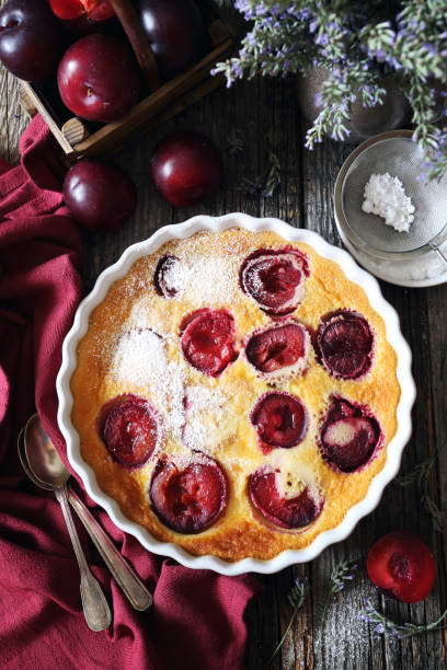 Red plums clafoutis with almonds stock photo