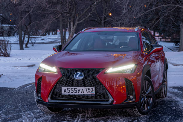 Red premium crossover hatchback Lexus UX on the city streets. Hybrid car in winter. stock photo