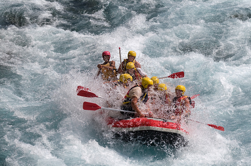 Group of people rafting on white water.