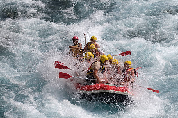 Red raft in violent white water Group of people rafting on white water. inflatable raft stock pictures, royalty-free photos & images