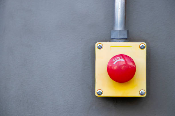 Red Reset button on the wall. red emergency stop switch button in a factory building. stock photo