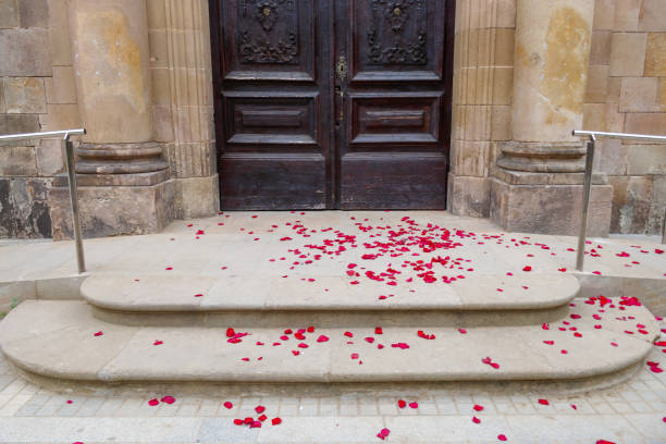 Red rose flower petals on the floor in front of the door of a church after a wedding. Divorce, settlement marriage sad concept. stock photo