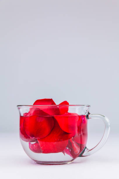 Red Rose Petals In A Glass Of Water stock photo