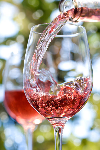 Red rose wine alfresco in glasses Glass of rose wine being poured outside. rose wine stock pictures, royalty-free photos & images