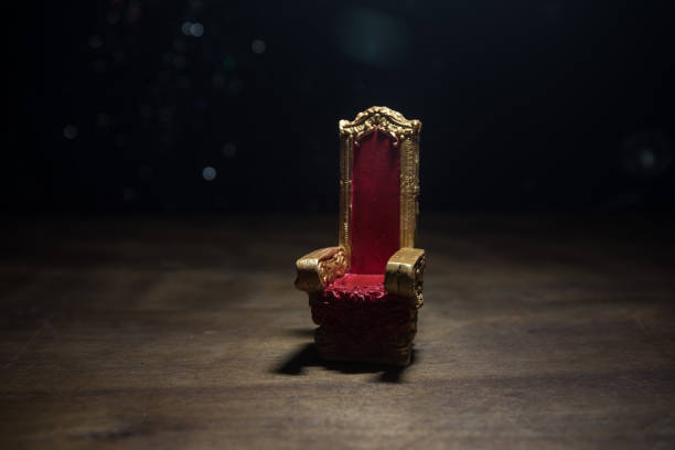 Red royal chair miniature on wooden table. Place for the king. Medieval Throne. stock photo
