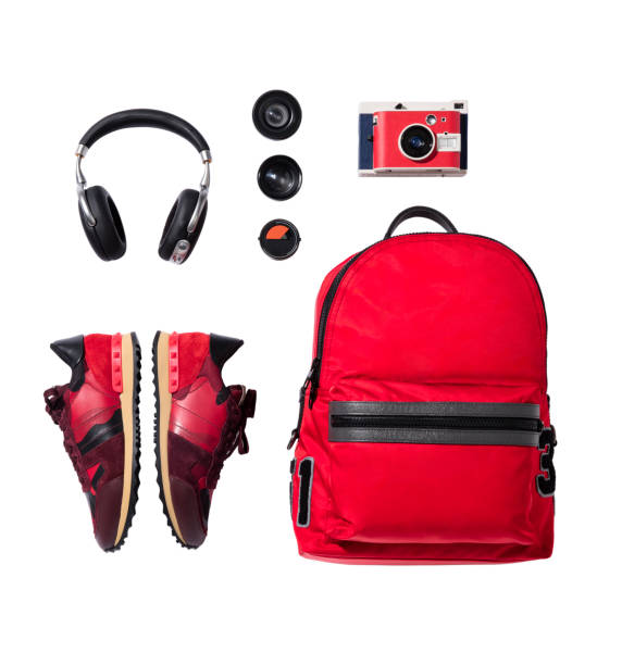 Red sneakers, backpack with camera and headphones isolated on white background stock photo