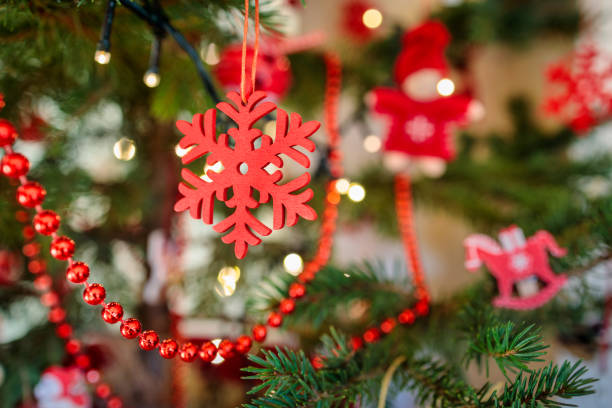 red snowflake shape handmade christmas decoration on a xmas tree stock photo