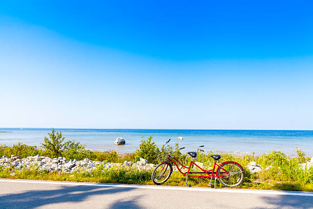 A red tandem bike parked on a beach road Red Tandem mackinac island stock pictures, royalty-free photos & images