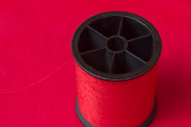 Red thread on red fabric background stock photo