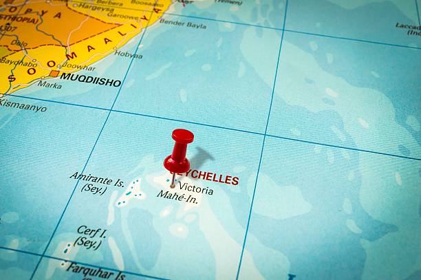 Red thumbtack in a map, pushpin pointing at Seychelles stock photo