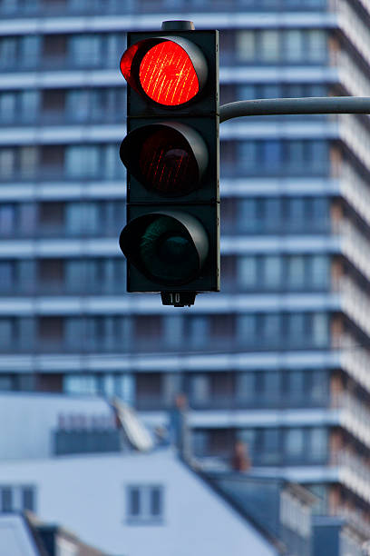 Red traffic light with modern facades in the background stock photo