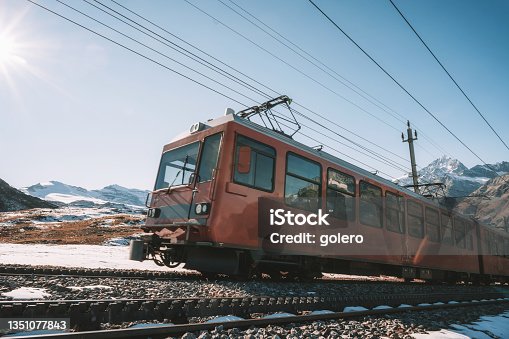 istock red train coming up mountain in the swiss alps 1351077843