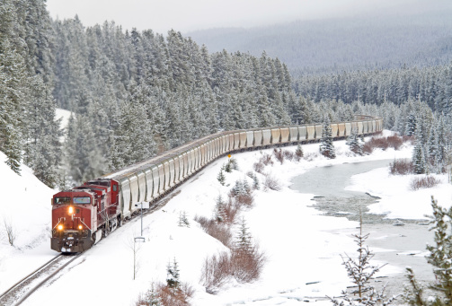 Red Train Speeding Through Rocky Mountains