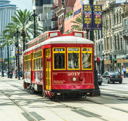 New Orleans, USA - July 17, 2013: red trolley streetcar on rail in New Orleans French Quarter. Newly revamped after Hurricane Katrina in 2005, the New Orleans Streetcar line began electric operation in 1893.