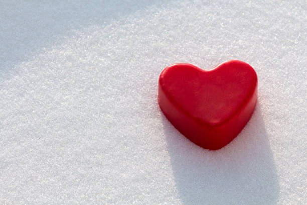 Red wax heart in the snow stock photo