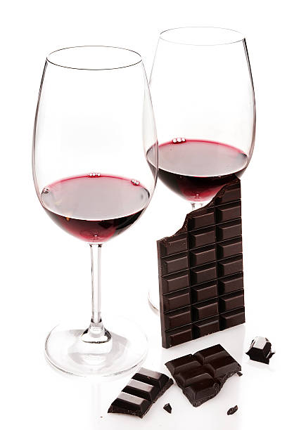 Red wine in glasses and dark chocolate isolated on white  stock photo