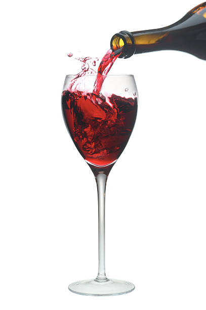 Red wine pouring into a glass. stock photo