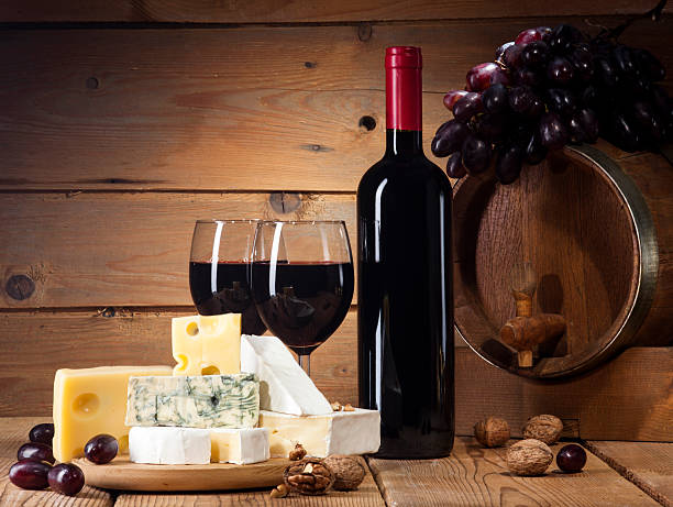 Red wine with various types of cheese on wooden background stock photo