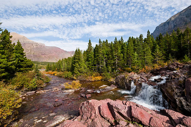 Redrock Falls Swiftcurrent Creek tumbles over Redrock Falls on its way to Swiftcurrent Lake. The characteristic red rock of the area gives the falls its name. This picture was taken near Redrock Lake in Glacier National Park, Montana, USA. jeff goulden glacier national park stock pictures, royalty-free photos & images