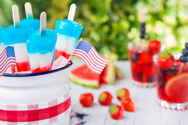 Homemade red-white-and-blue popsicles on an outdoor table.
