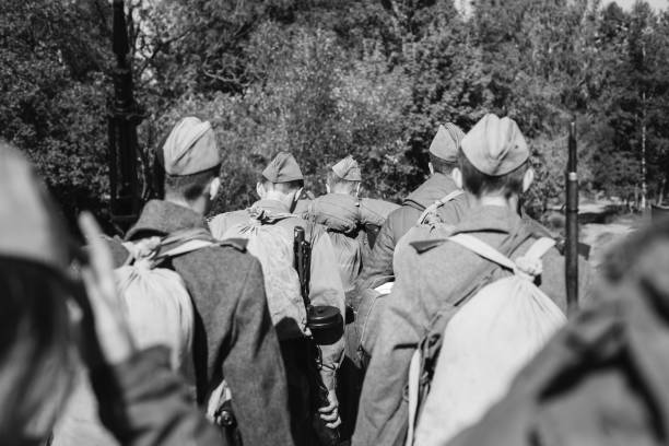 re-enactors przebrany za ii wojny światowej rosyjskich żołnierzy radzieckiej armii czerwonej maszerujących przez las w jesienny dzień. zdjęcie w kolorach czarno-białym. żołnierz ii wojny światowej - russian army zdjęcia i obrazy z banku zdjęć