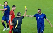 Referee showing yellow card during football match.