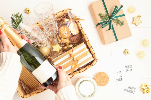 Refined Christmas gift basket for romantic holidays with bottle of champagne, wine glasses, cookies and candle stock photo