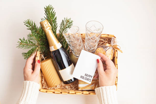 Refined Christmas gift basket for romantic holidays with bottle of champagne, wine glasses, cookies and candle stock photo