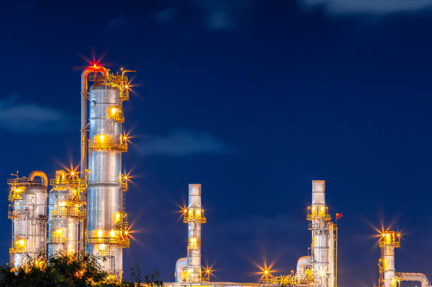 refinery oil and gas industry at night blue sky after sunset time with chemical and petroleum for energy of transportation and electricity product, as business economy industrial stock photo