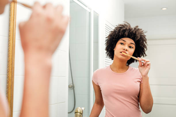 reflektion av en ung kvinna i spegeln borsta tänderna - kvinna borstar tänderna bildbanksfoton och bilder