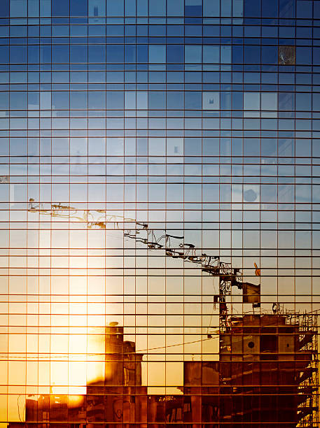 Reflection of construction work in a windowed building stock photo