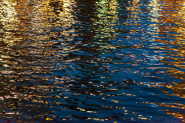 Reflections of Light on Water at Night stock photo