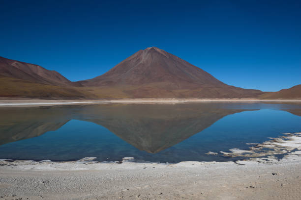 Reflections of mountains in the clear water of the Green Lake (Laguna Verde) on the Bolivian altiplano stock photo
